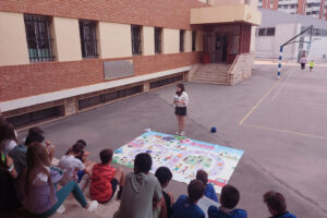 Alumnado del colegio La Salle de Teruel en el patio junto a la lona del juego ciudades accesibles